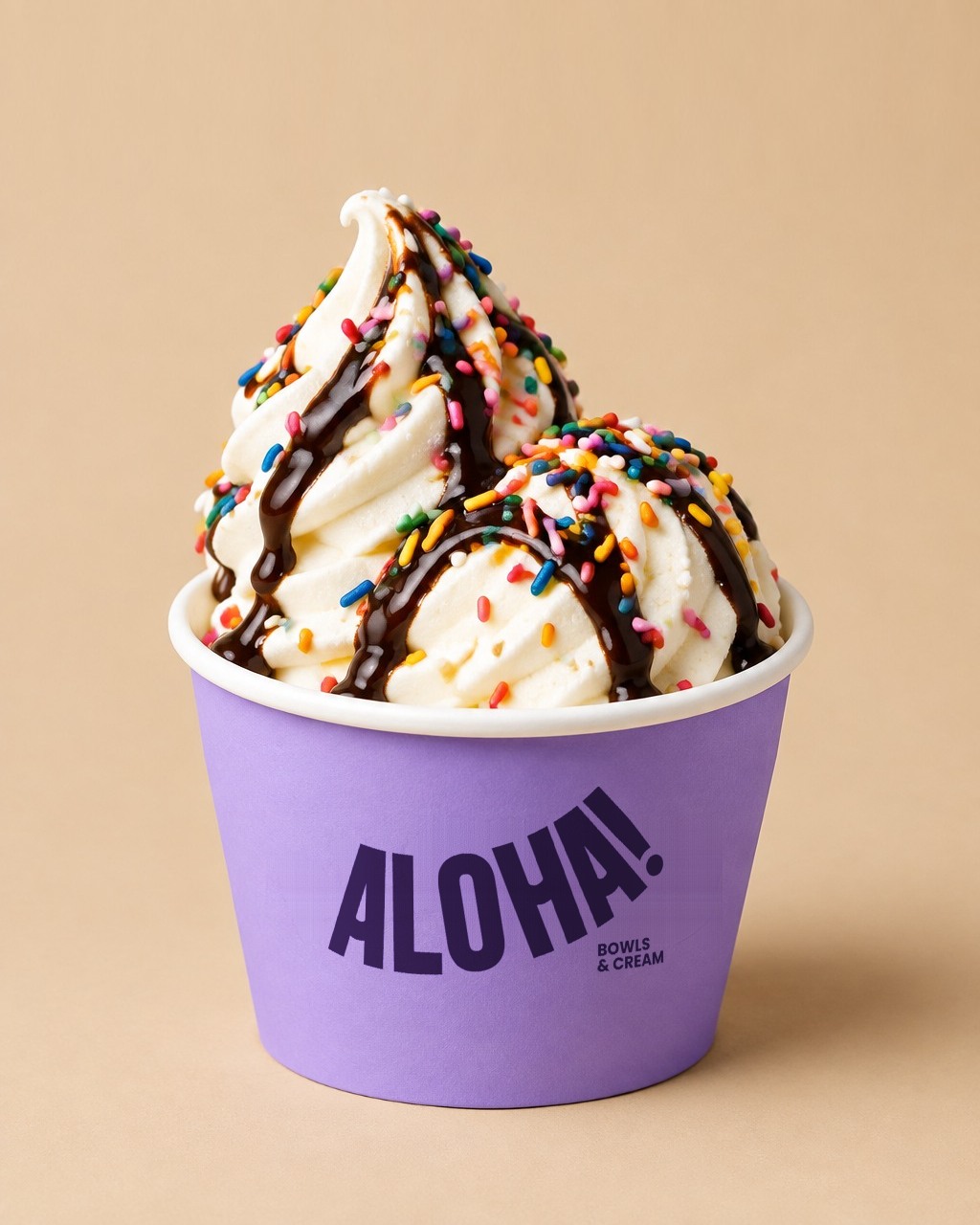 Ice cream cup with chocolate drizzle and rainbow sprinkles in an ALOHA! cup